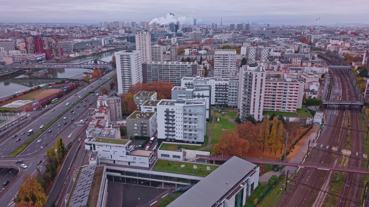 Drone flies forward over railway and beltway with Paris skyline visible in distance