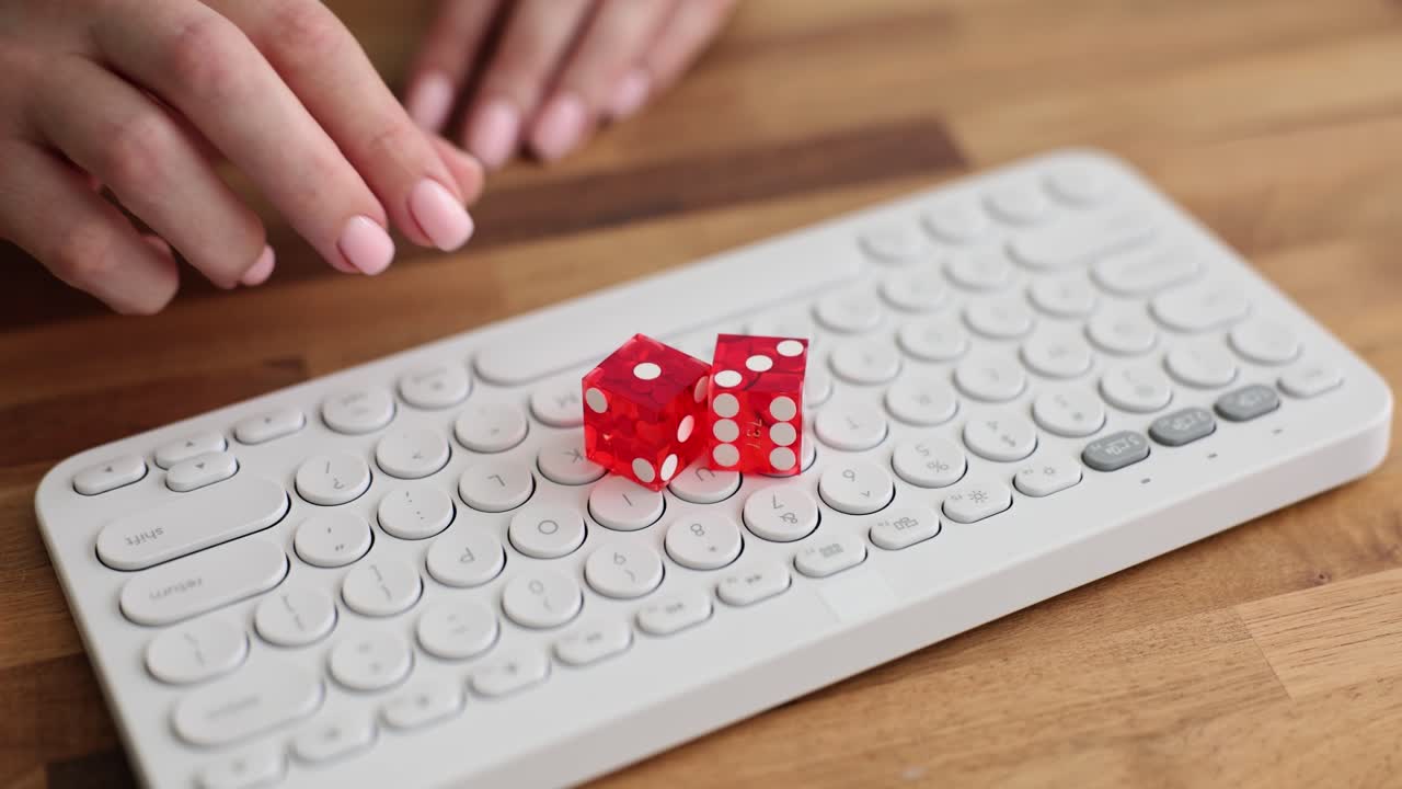 Hands Placing Red Dice on a White Computer Keyboard