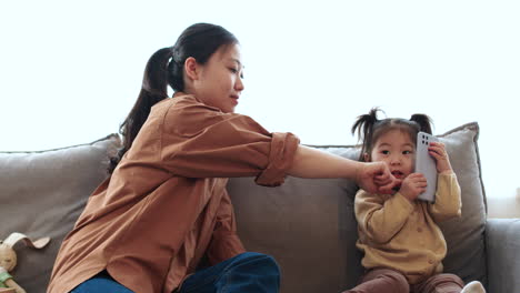 Asiatische-Mutter-Mit-Ihrem-Baby-Auf-Dem-Sofa