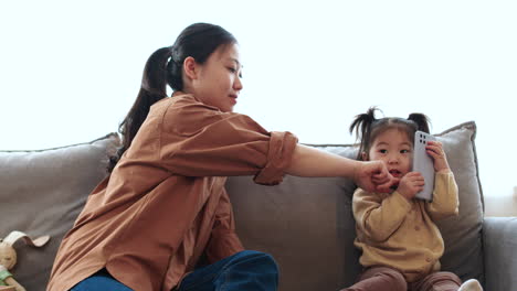 asian mother with her baby on the sofa