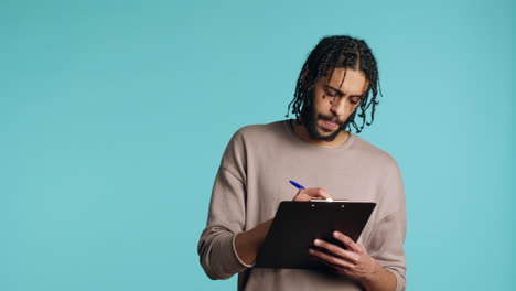 creative man brainstorming ideas, writing on paper using pen, studio background