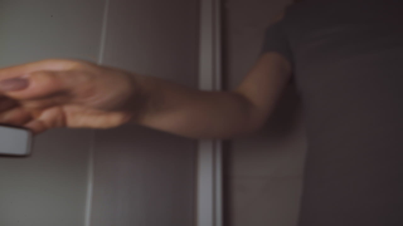 Young woman turns metal knob to come into small restroom