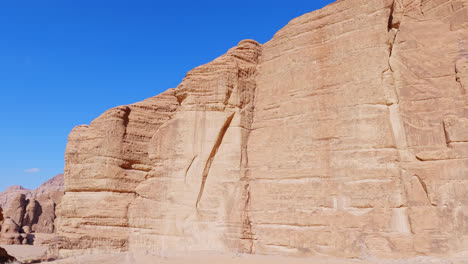 Enormes-Bloques-De-Arenisca-Crean-Escarpados-Acantilados-Contra-El-Cielo-Azul-Brillante,-Wadi-Rum