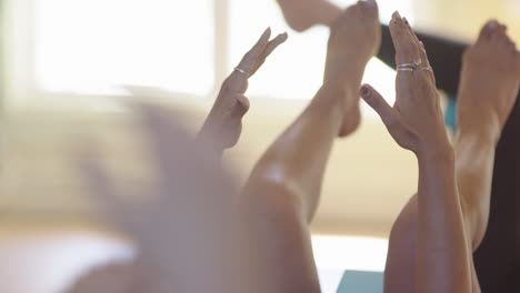 Yogis-on-backs-use-yoga-blocks-during-yoga-class,-shallow-depth-rack-focus