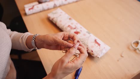 La-Mujer-Prepara-Una-Cuerda-Para-Usarla-Como-Decoración-De-Un-Regalo-De-Navidad,-Primer-Plano