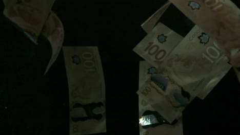 falling flying american canadian dollar banknotes on a black background in 4k loopable. high quality falling dollar banknotes in 4k. video is loopable