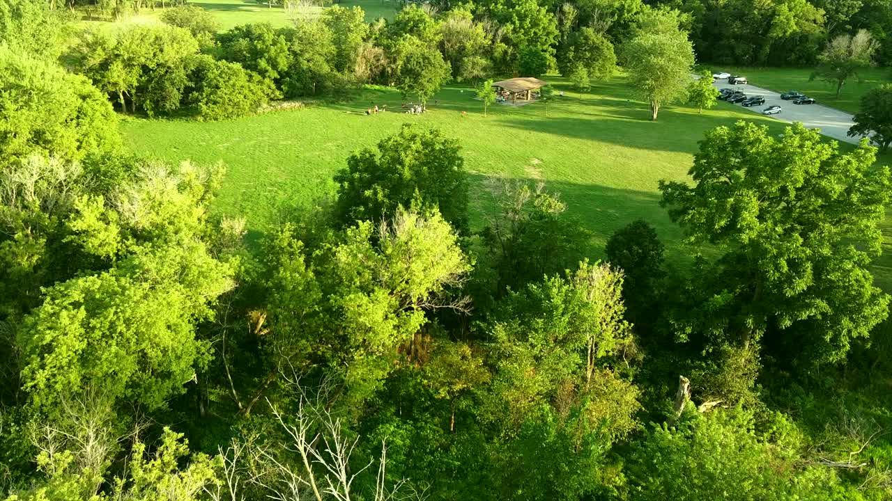 вид с беспилотного летательного аппарата на людей, развлекающихся в парке на закате летнего дня