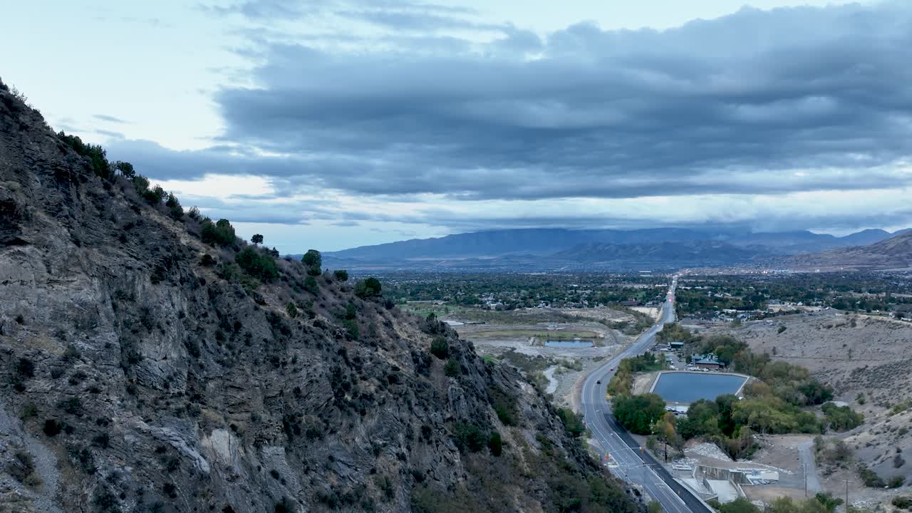 American Fork Canyon's rugged landscape overlooking Utah Valley at dawn Descending aerial view. The dramatic skies and serene environment create a breathtaking aerial perspective
