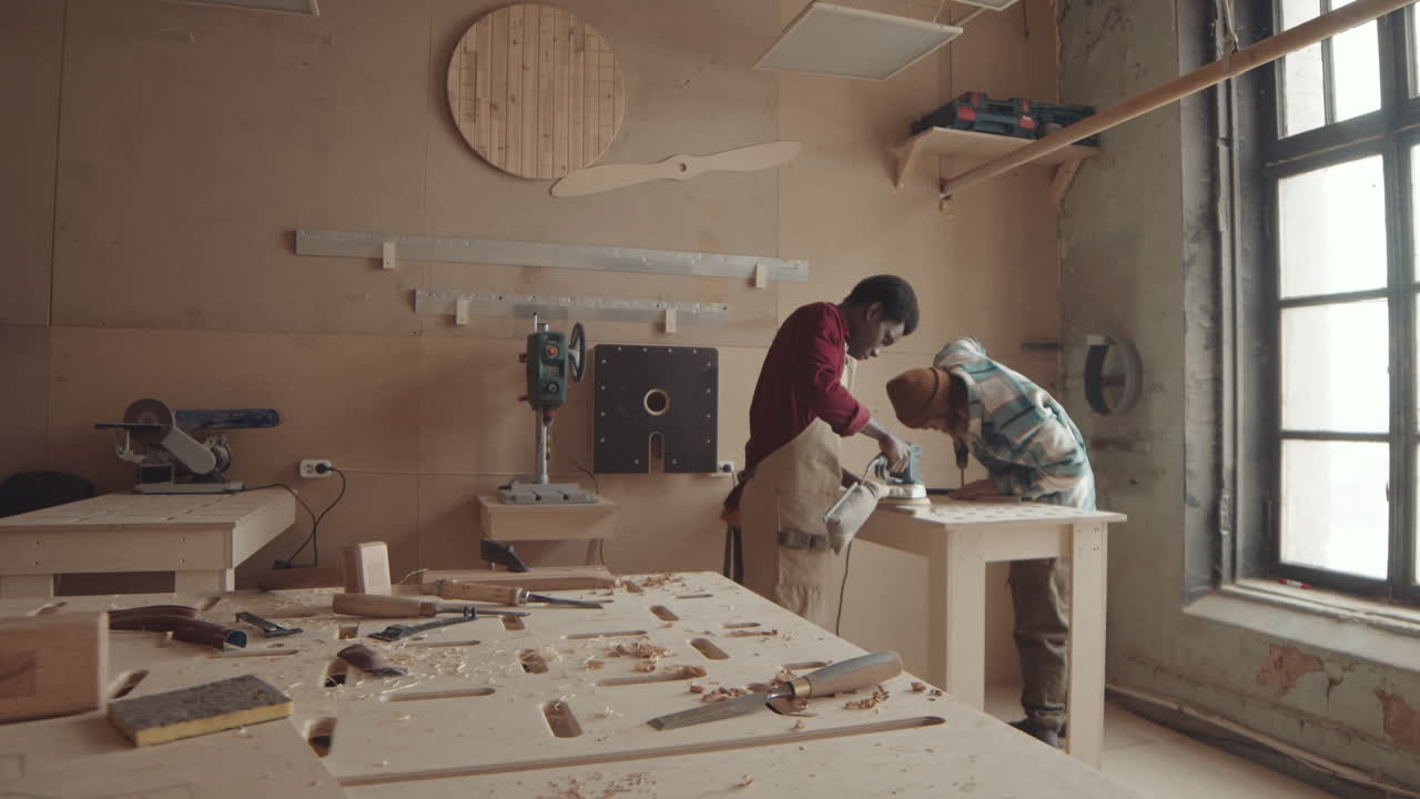 Pair of Young Multiethnic Joiners Working in Workshop