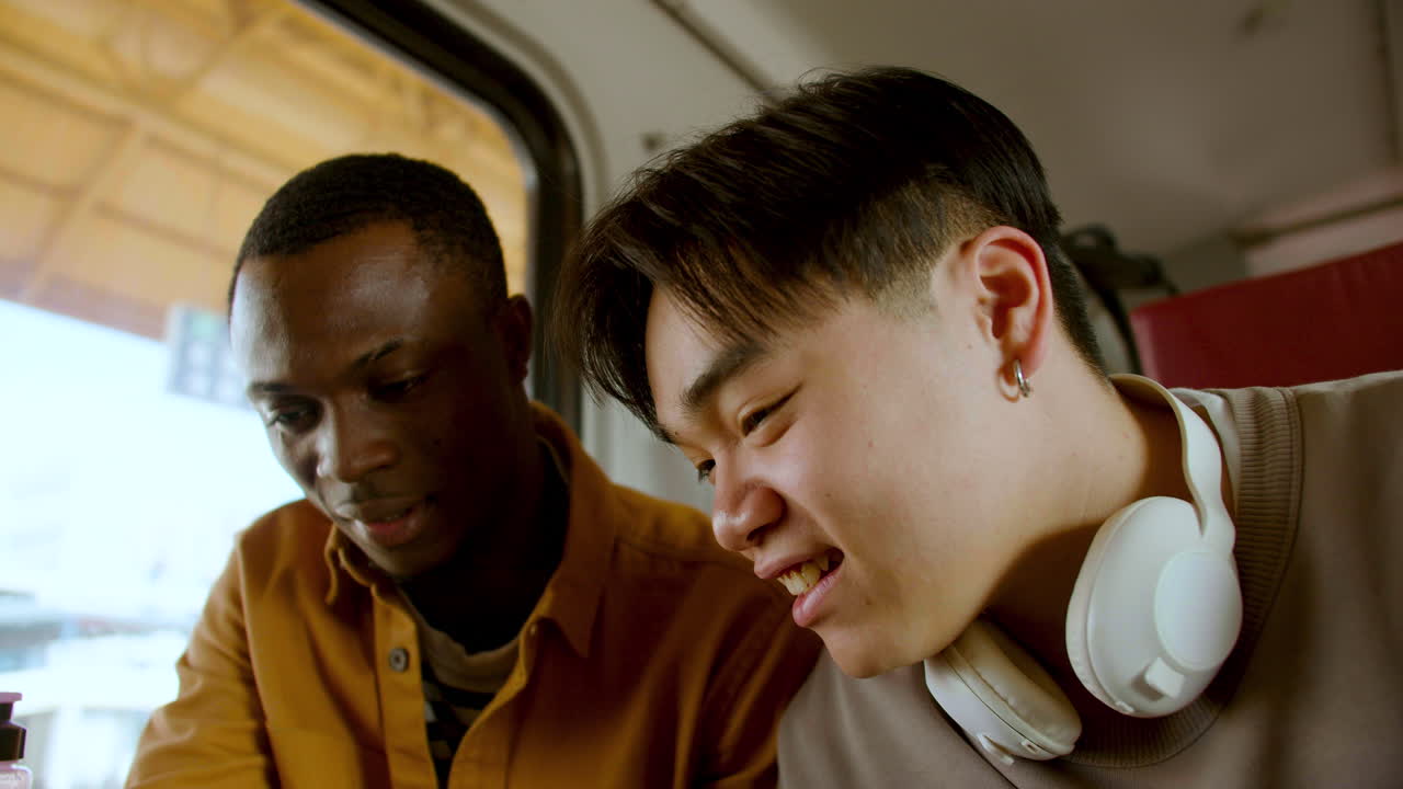 친구 들 이 열차 에서 동영상 을 보고 있다