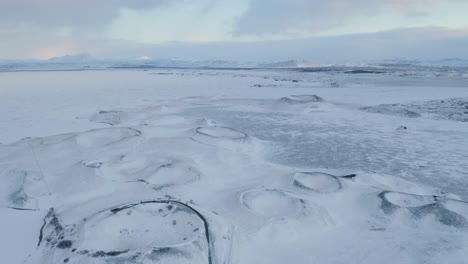 Luftüberführung-Zugefrorener-See-My-Vatn-Mit-Mehreren-Schneebedeckten-Kratern-In-Island,-Europa