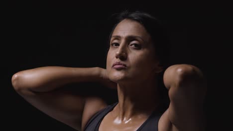 Studio-Portrait-Of-Mature-Woman-Wearing-Gym-Fitness-Clothing-Sweating-After-Exercise