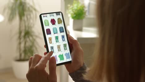 a woman looks at the screen of a smartphone fashionable clothes. e-commerce concept. online purchase of goods in the store, marketplace, using the phone.