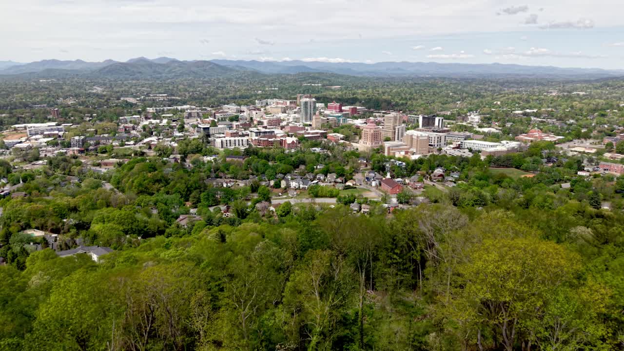 Ripresa aerea in avvicinamento allo skyline di Asheville, Carolina del Nord, sopra la cima della montagna.