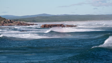 powerful atlantic swell surges toward coast with sea spray blown over crest