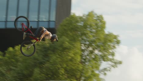 huge bmx backflip trick done off of a jump in industrial location