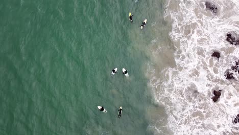 Aéreo---Tiro-De-Ojo-De-Pájaro-Con-Drones-Rastreando-A-Los-Surfistas-Remando-En-El-Oleaje-Del-Océano-En-Tasmania