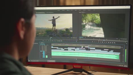 asian male video editor works with footage and sound on his personal computer, he works late at night