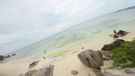 fpv drone flying on a anse source d'argent beach in seychelles on an island mahe, video of incredible trees, seychelles rocks, seaside, and surrounding seychelles landscapes