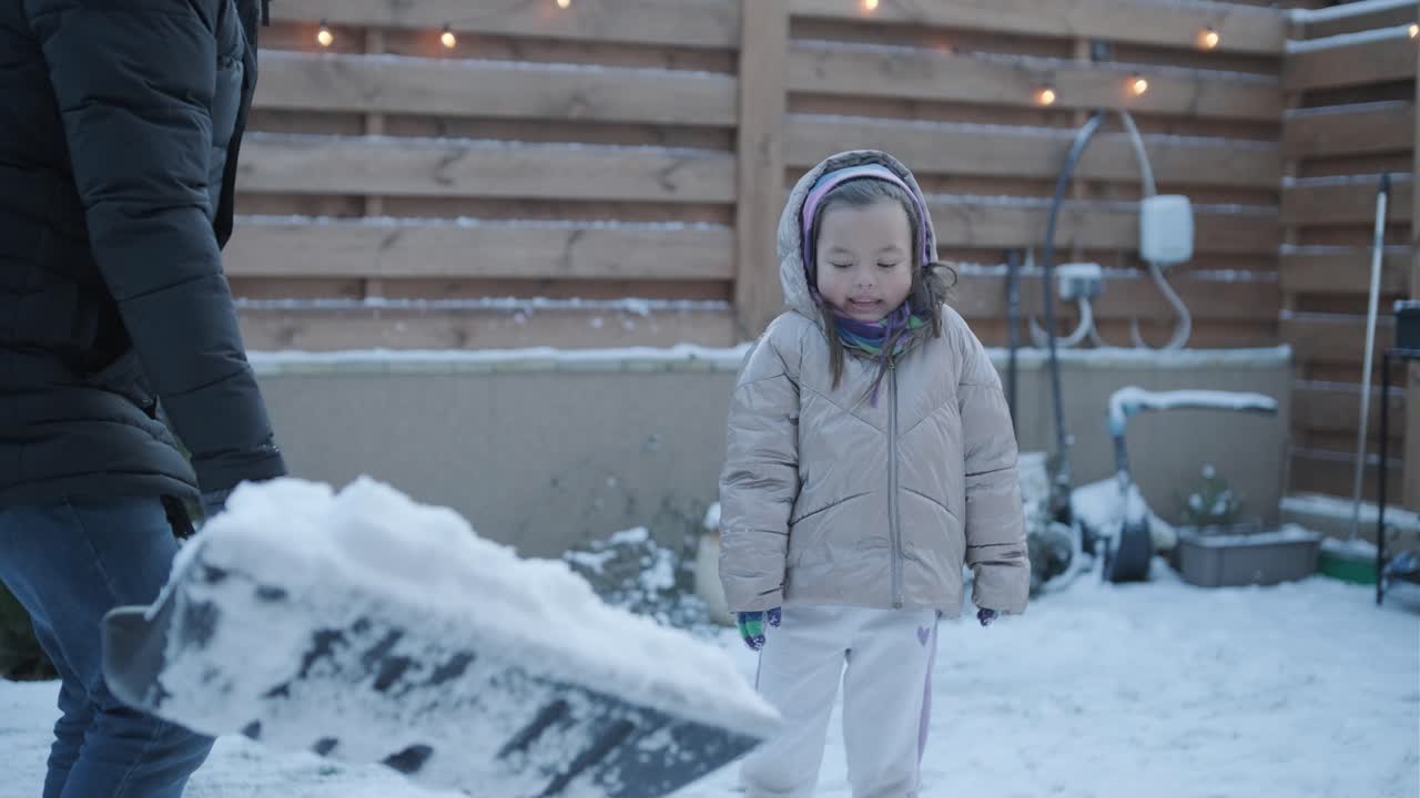 дедушка и внучка веселятся в снегу.