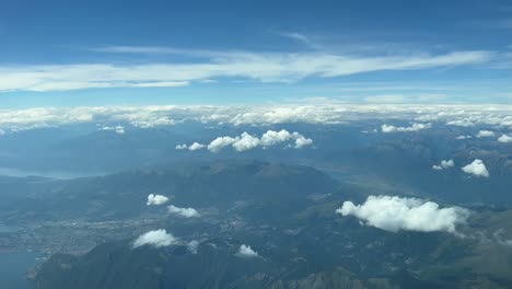 Aerial-cockpit-view,-pilot-pov,-of-the-italian-Alps,-with-a-nice-landscape-of-mountains,-valleys-and-lakes