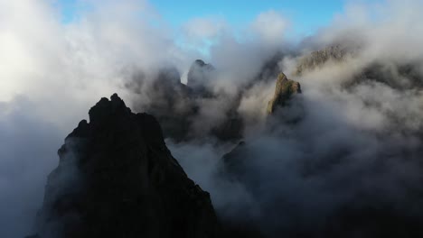 drone shot moving forward among the peaks of pico das torres in madeira