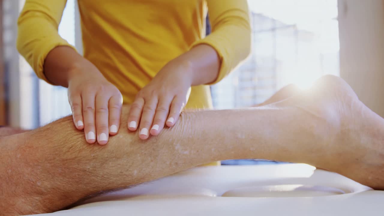 Physiotherapist giving leg massage to a man 4k