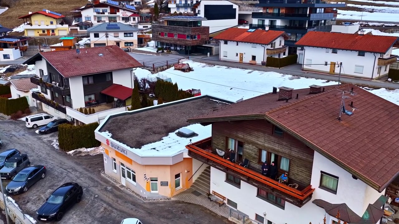 Vista aérea de un pueblo con nieve y montañas circundantes.