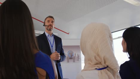 orador masculino con micrófono de auriculares dirigiéndose a la audiencia en un seminario de negocios