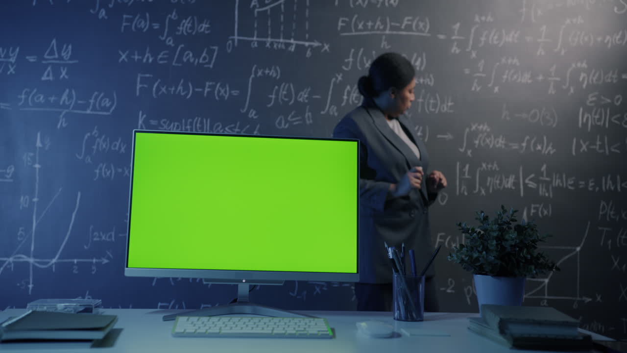 Woman Teacher Giving Lecture in Front of Green Screen Monitor, Math Classroom Setting