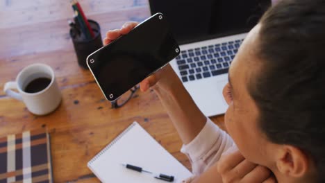 Mujer-Caucásica-Sosteniendo-Un-Teléfono-Inteligente-En-Videollamada,-Trabajando-Desde-Casa