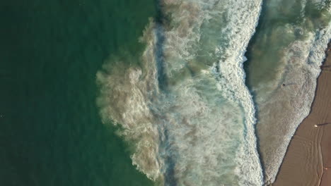 bird's eye view of foamy waves in llandudno beach, cape town, south africa - aerial drone