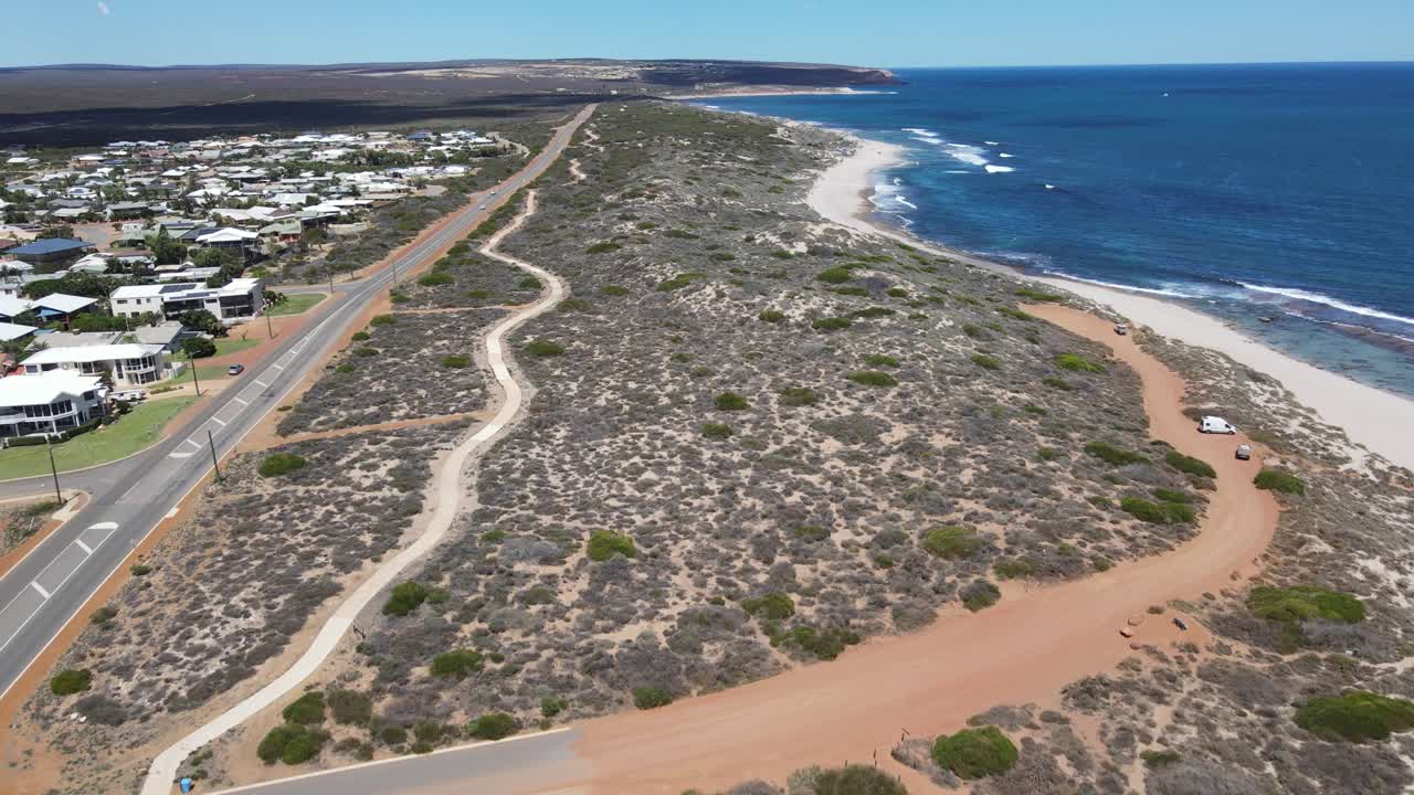 드론 항공기 는 오스트레일리아 의 파란 해변  에 있는 시골 도로 를 보여 준다