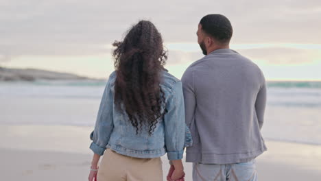 Couple,-holding-hands-and-walking-at-the-beach