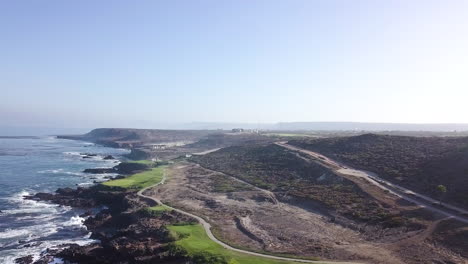 Drone-flys-right-to-left-with-large-wide-views-of-a-beachside-golf-course-and-Baja's-desert-landscape