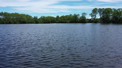 Ein-Low-Angle-Shot-über-Einen-Teich-Mit-Sanften-Wellen-Im-Wasser