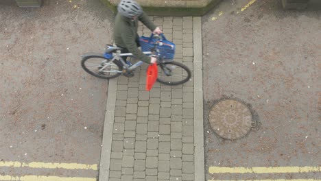 Man-walking-with-bicycle-and-groceries-on-street