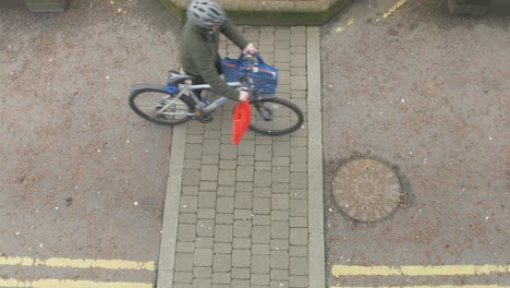 hombre caminando con bicicleta y comestibles en la calle