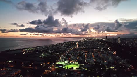 aerial coastal cityscape pan view over santo domingo at sunset