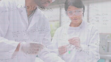 mathematical equations floating against male and female health workers working at laboratory