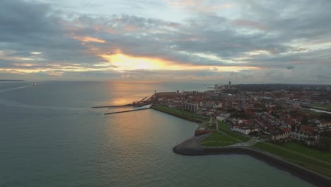 Aerial:-The-boulevard,-beach-and-city-of-Vlissingen-during-sunset