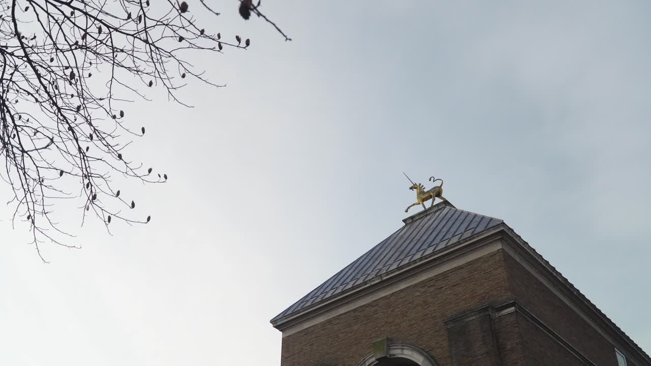 BRISTOL, SOMERSET, UNITED KINGDOM,  Beautiful gold unicorn on top of a roof building.