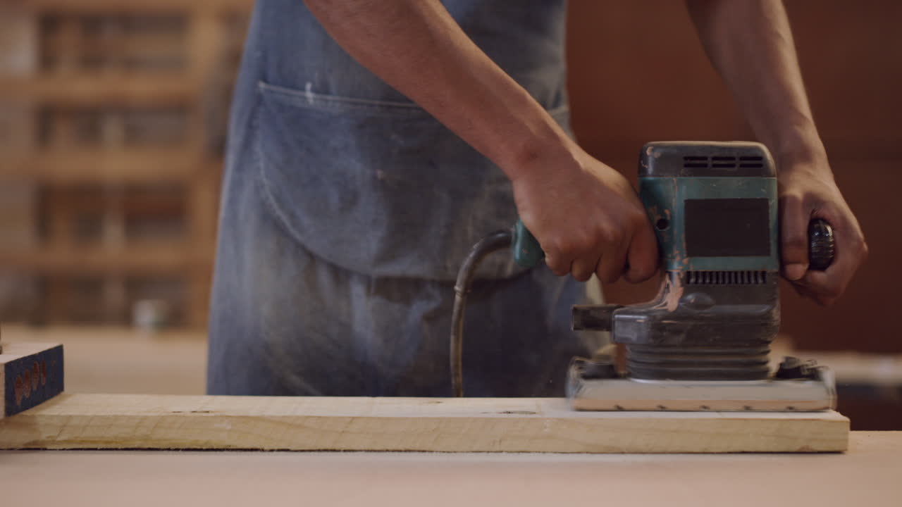 carpintero usando una lijadora eléctrica en la madera