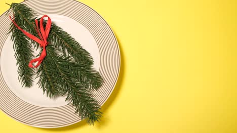 festive holiday decoration with pine and red ribbon on plate