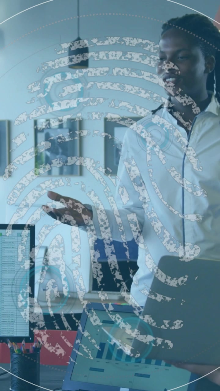 Vertical video: Man speaking, voice causing ID overlay growing over laptop, obscuring him for tech