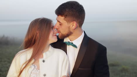 Newlyweds.-Caucasian-groom-with-bride-on-the-morning-field.-Fog.-Wedding-couple