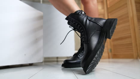 leather army fashionable stylish black boots demonstrated by the female model. woman turning her feet in front of camera. close up.