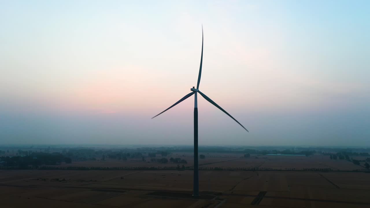 Aerial: wind turbine at sunrise in Bozhou, Anhui province, China, orbit drone shot