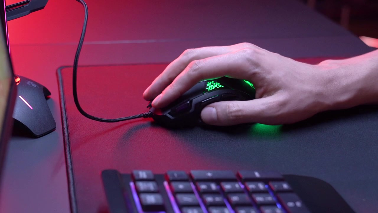 Gamer's Hand Clicking RGB Gaming Mouse on Desk