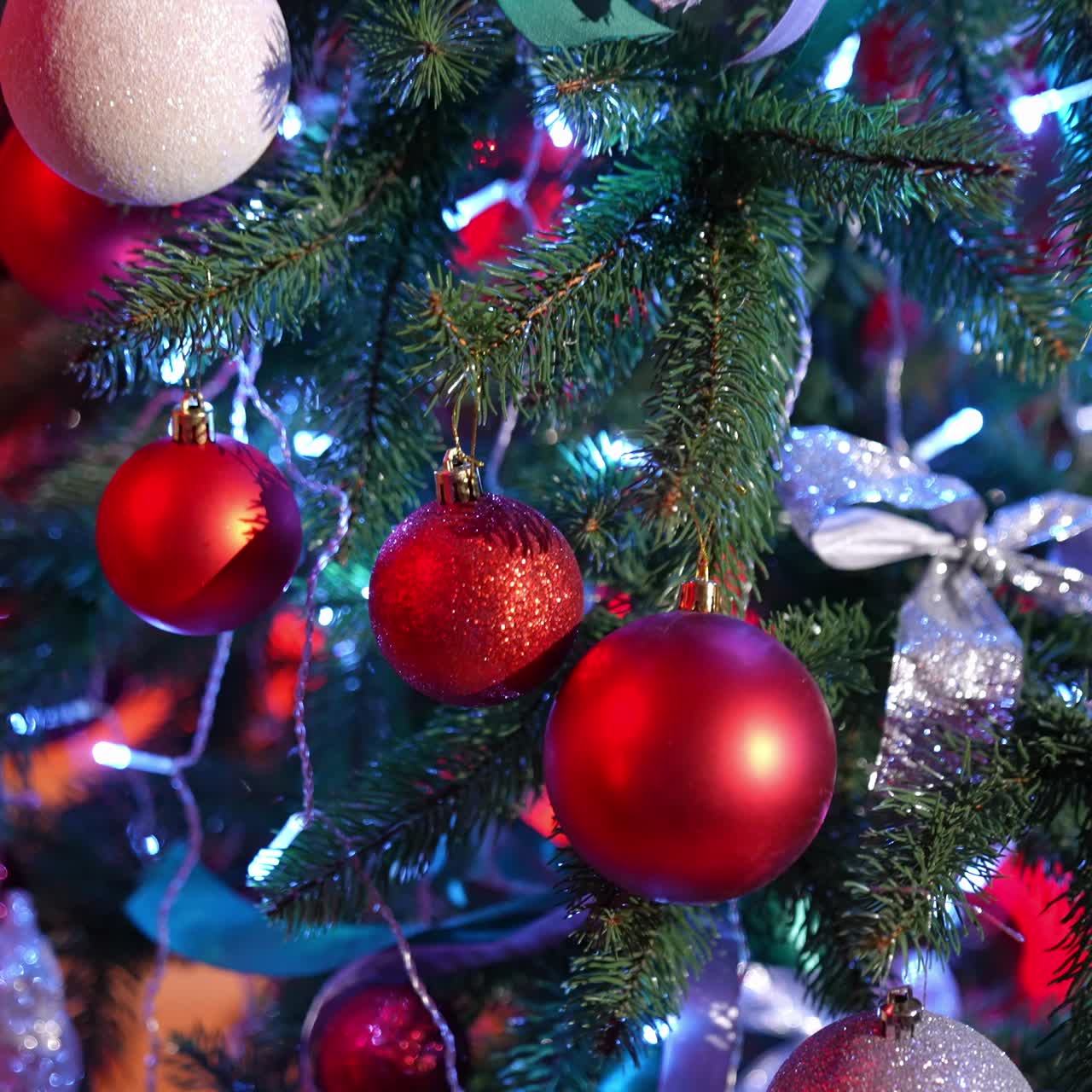 Christmas tree. Beautiful New year fir tree with bright Christmas balls and ribbons. Close-up. Festive atmosphere at winter holidays